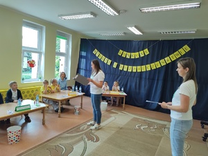 prowadzące konkurs w tle uczestnicy i okna w sali