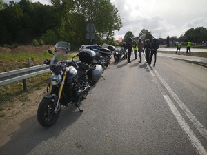 policjant kontroluje motocyklistę w tle droga