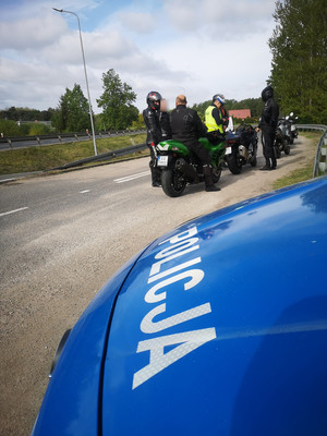 policjant kontroluje motocyklistę w tle droga