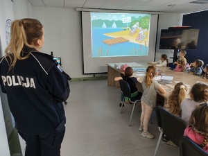 dzieci zwiedzają komendę w tle budynek komendy