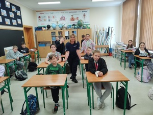 policjantka z uczniami pozuje do zdjęcia w tle sala lekcyjna