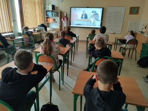 uczniowie oglądają film w tle sala lekcyjna
