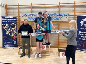 zawodnicy na podium w tle drabinki