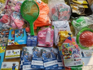 policjanci bawią się z dziećmi w tle teren zewnętrzny jednostki, radiowozy, banery, dzieci i dorośli