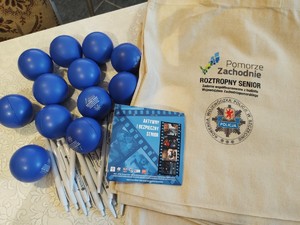 policjanci rozmawiają z seniorami w tle pomieszczenie