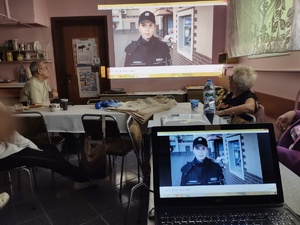 policjanci rozmawiają z seniorami w tle pomieszczenie