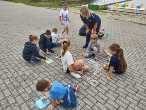 policjantka rozmawia z dziećmi w tle jezioro