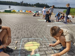 policjantka rozmawia z dziećmi w tle jezioro