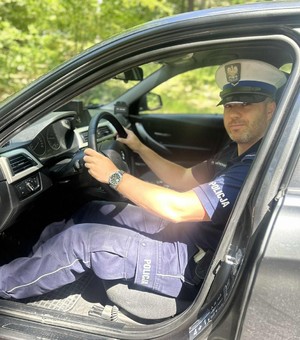 policjant w mundurze siedzi w radiowozie
