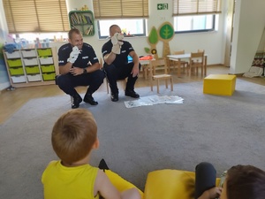 policjanci rozmawiają z dziećmi w tle wyposażenie sali