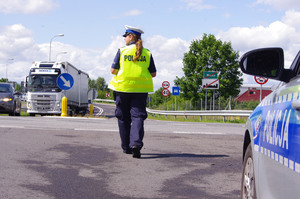 policjantka ruchu drogowego stoi na drodze w tle pojazdy