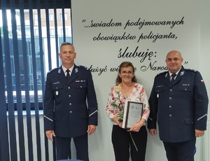 pracownica na zdjęciu z komendantami w tle ściana