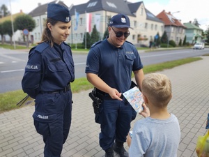 policjanci rozmawiają z dziećmi w tle ulica