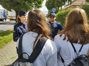 policjanci rozmawiają z dziećmi w tle