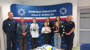 Komendant wręcza nagrody uczestnikom konkursu w tle baner