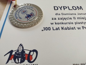 Komendant wręcza nagrody uczestnikom konkursu w tle baner