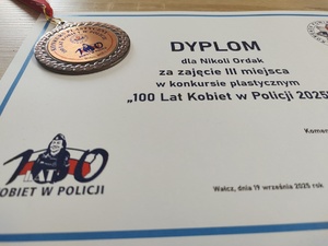 Komendant wręcza nagrody uczestnikom konkursu w tle baner