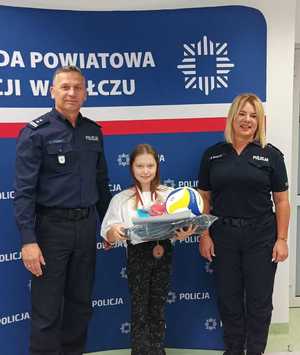 Komendant wręcza nagrody uczestnikom konkursu w tle baner