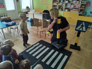 Policjantka rozmawia z przedszkolakami w tle sala