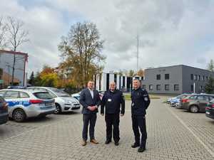 komendanci i burmistrz soją na placu komendy w tle budynek komendy i pojazdy