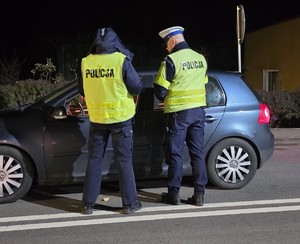 policjanci kontrolują kierowców w tle wieczór i droga
