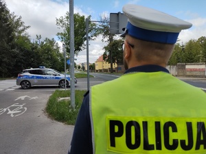 policjant w tle światła błyskowe radiowozu