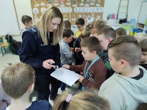 policjantka rozmawia z uczniami w tle klasa