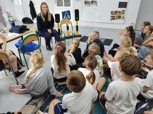 policjantka rozmawia z uczniami w tle klasa