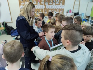 policjantka rozmawia z uczniami w tle klasa
