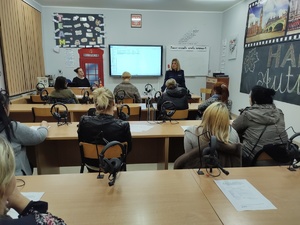 policjantka rozmawia z rodzicami w tle sala lekcyjna