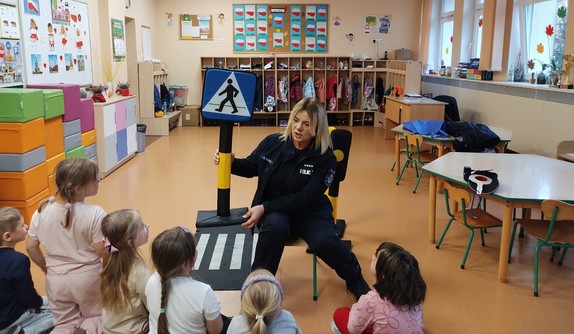 policjantka rozmawia z dziećmi w tle sala