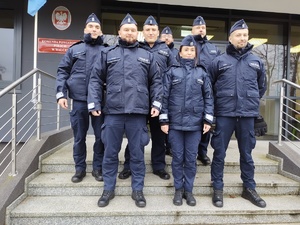 policjanci pozują do zdjęcia w tle budynek komendy