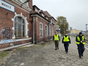 służby kontrolują przejazdy kolejowe w tle tory