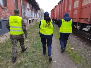 służby kontrolują przejazdy kolejowe w tle tory