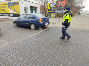 policjantka kontroluje pojazd w tle pojazdy i ulica