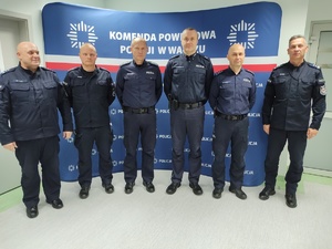 komendant wręcza awanse i nagrody w tle baner z logo policji