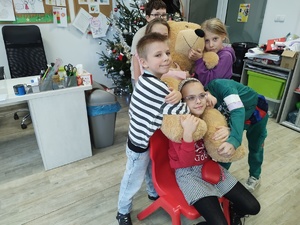 policjant uczy udzielania pierwszej pomocy, w tle sal