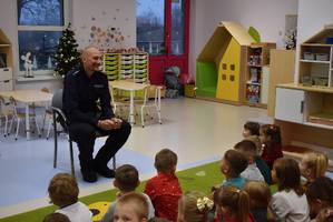 policjant rozmawia z dziećmi ew tle sala