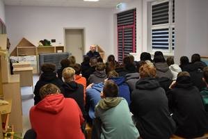 policjant rozmawia z dziećmi w tle sala