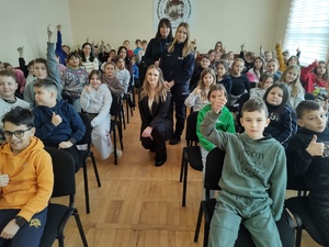 wspólne zdjęcie prowadzących z uczniami w tle ściana w sali