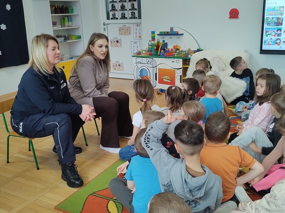 policjantka i przedstawicielka sanepidu rozmawiają z dziećmi w tle wyposażenie sali