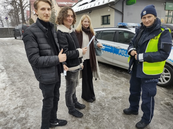 policjanci rozmawiają i wręczają odblaski pieszym