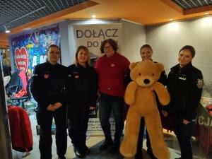 policjantki rozmawiają z uczestnikami WOŚP w tle hol i ludzie