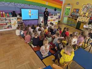 policjanci rozmawiają z przedszkolakami w tle sala