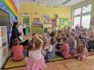 policjanci rozmawiają z przedszkolakami w tle sala