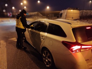 policjant bada trzeźwość kierowcy, w tle ulica i radiowóz