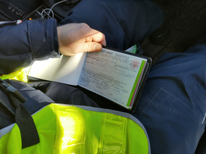 druk mandatowy na kolanach policjanta