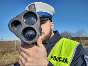policjant mierzący prędkość w tle błękitne niebo