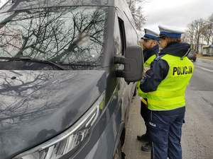policjanci kontrolują pojazdy w tle ulica