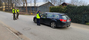 policjanci sprawdzają stan trzeźwości kierowców w tle zabudowania